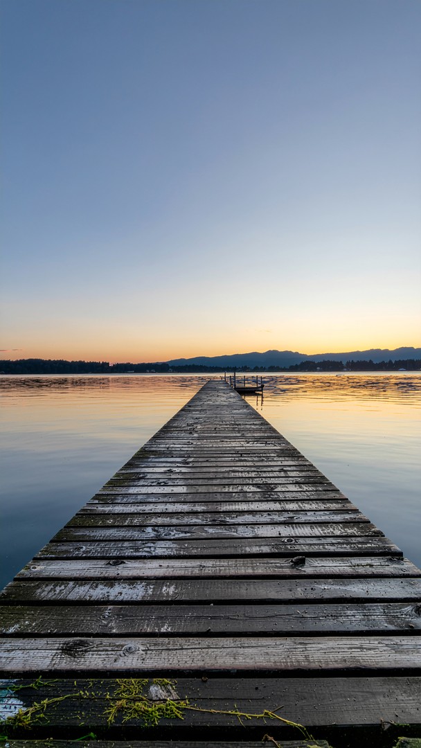 ​Wooden Pier Sunset Wallpaper - Calm Lake & Mountain Horizon 4K